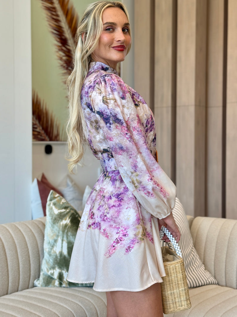 Soft pastel mini dress with painterly blooms and button-front detail.