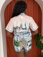 Model wearing Santorini-inspired co-ord with whitewashed buildings.