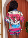 Model wearing colorful Mediterranean-style two-piece with coastal views.