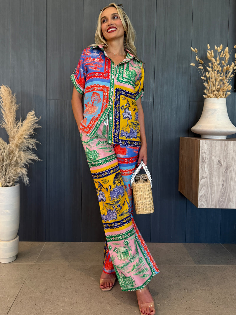 Short-sleeve button-up and wide-leg pants with bold graphic print.