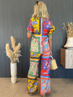 Model wearing multicolor two-piece set featuring vintage-style scenery.