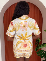Model wearing floral two-piece set with yellow and coral tones.