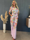Stylish woman in satin floral print loungewear posing indoors.