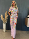 Woman in pastel floral resort set with wide-leg pants and short-sleeve top.