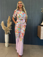 Woman in pastel floral resort set with wide-leg pants and short-sleeve top.