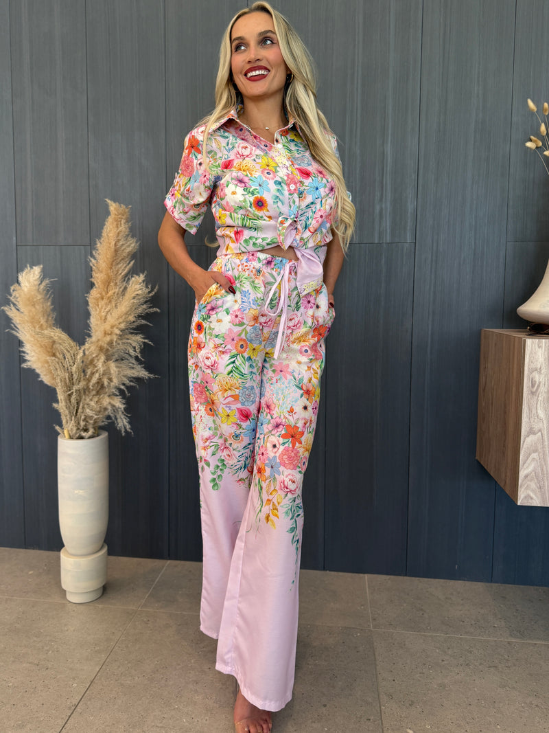 Stylish woman in satin floral print loungewear posing indoors.