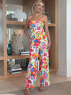 Woman in colorful strapless jumpsuit with fruit and market-inspired print.