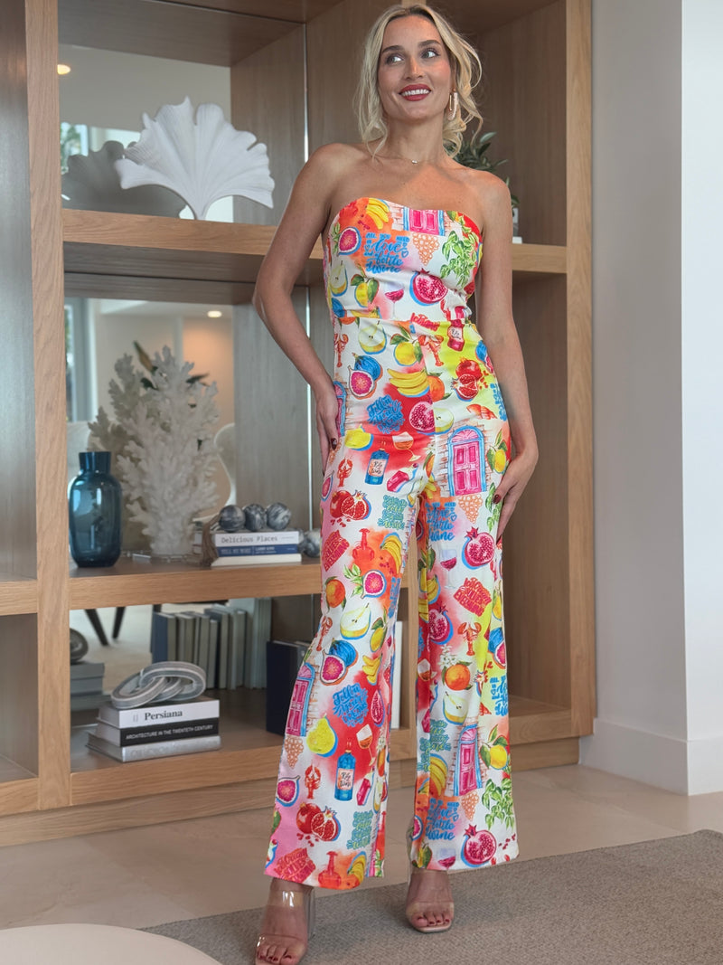 Strapless one-piece with multicolor fruit pattern and bold travel vibes.