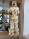 Model wearing wide-leg jumpsuit with palm and flower motifs.