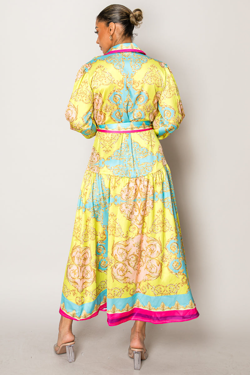 Model wearing a colorful long-sleeve vacation dress with pink trim